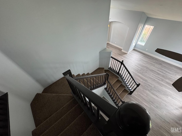 6100 Aruba Ct, Bakersfield, CA 93313 - stairway featuring arched walkways, baseboards, and wood finished floors