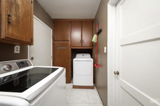 laundry area with cabinets, light tile patterned floors, and independent washer and dryer