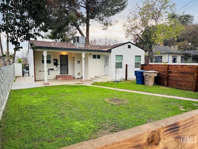 back of property featuring fence private yard, a yard, and stucco siding