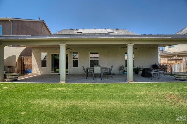 6207 Provincetown Ave, Bakersfield, CA 93313 - rear view of house featuring a ceiling fan, stucco siding, roof mounted solar panels, a patio, and outdoor dining space