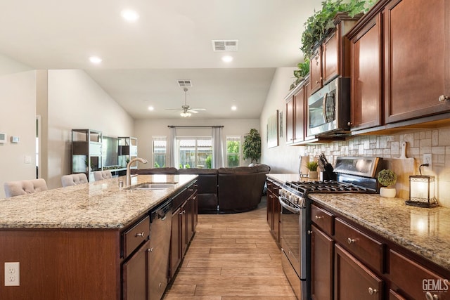 6207 Provincetown Ave, Bakersfield, CA 93313 - kitchen featuring stainless steel appliances, open floor plan, light wood-type flooring, ceiling fan, and light stone counters