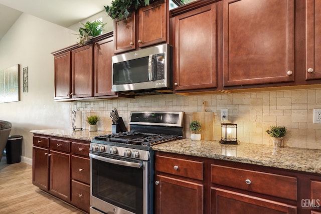 6207 Provincetown Ave, Bakersfield, CA 93313 - kitchen featuring stainless steel appliances, backsplash, light wood-type flooring, and light stone counters