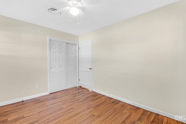 empty room with hardwood / wood-style floors and ceiling fan