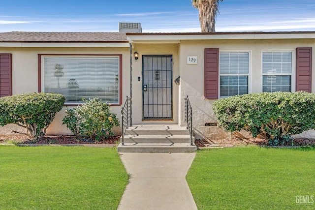 view of exterior entry featuring a yard