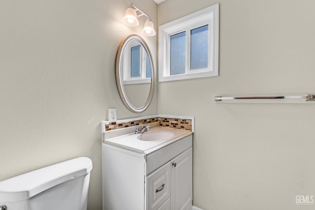 bathroom with vanity, toilet, and backsplash