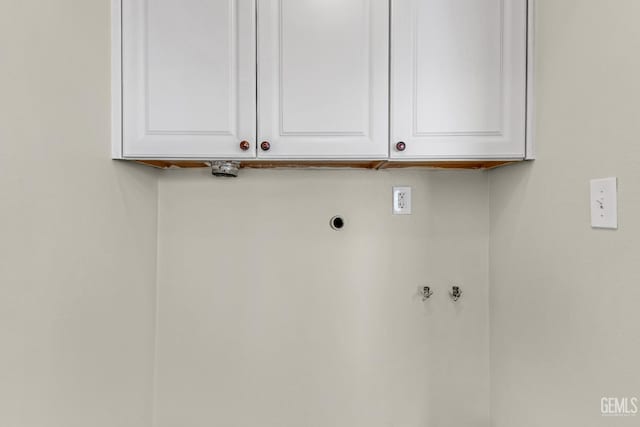 clothes washing area featuring cabinets and hookup for an electric dryer