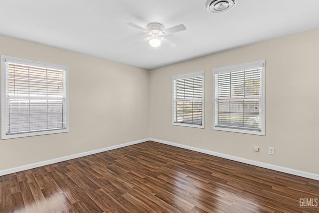 spare room with dark wood-type flooring and ceiling fan