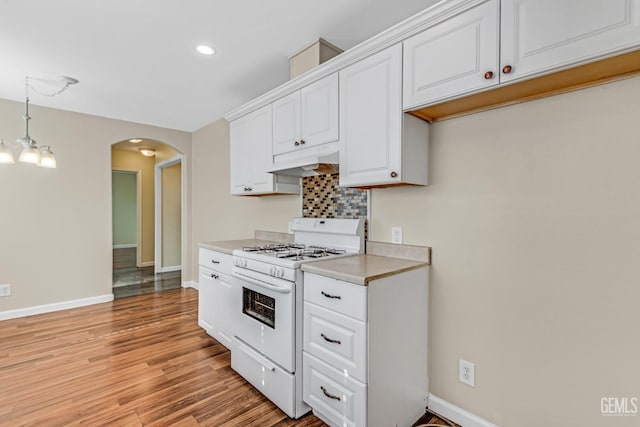 kitchen featuring white cabinetry, a chandelier, hanging light fixtures, light hardwood / wood-style flooring, and white range with gas cooktop