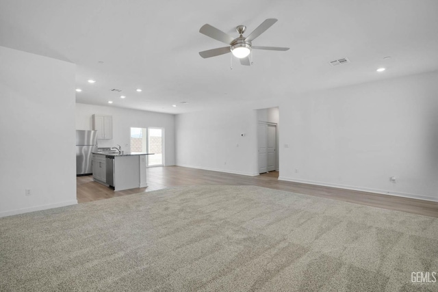 unfurnished living room with light colored carpet, ceiling fan, and recessed lighting
