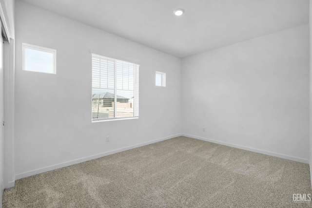 carpeted empty room with plenty of natural light and baseboards