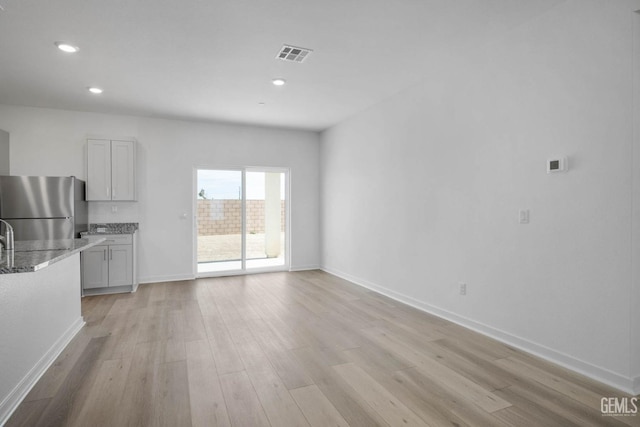 interior space with visible vents, recessed lighting, light wood-style flooring, and baseboards