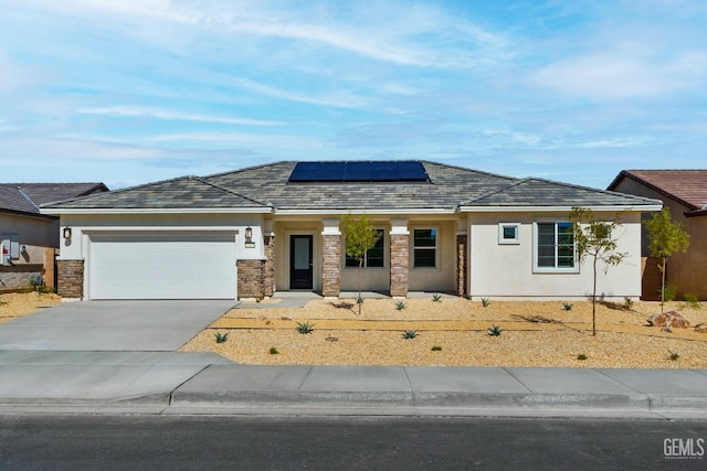 view of front of house with driveway, solar panels, stucco siding, and an attached garage