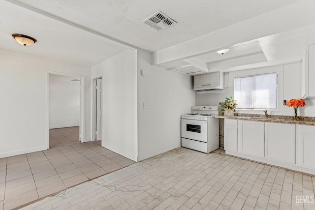 kitchen featuring a textured ceiling, white range oven, sink, light tile patterned floors, and white cabinetry