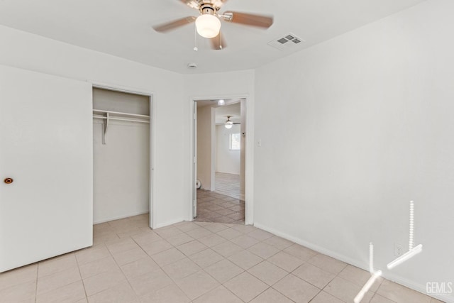 unfurnished bedroom featuring ceiling fan, light tile patterned floors, and a closet