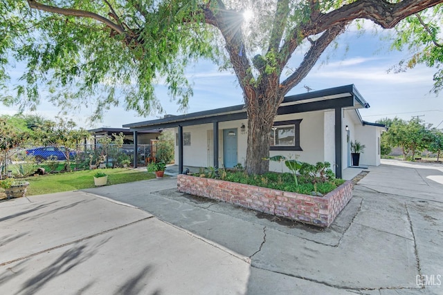 ranch-style house featuring covered porch and a front yard