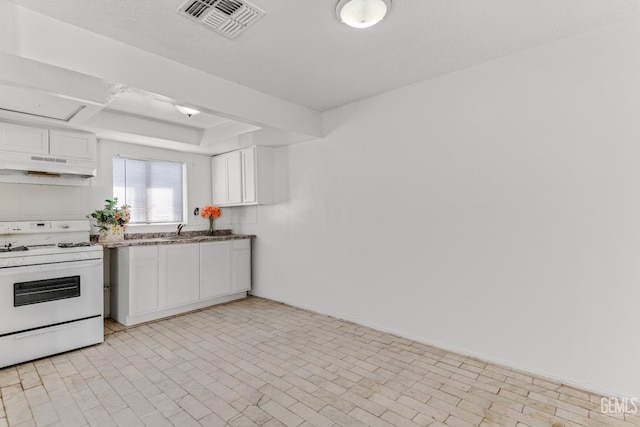 kitchen featuring a textured ceiling, white cabinetry, sink, and white stove