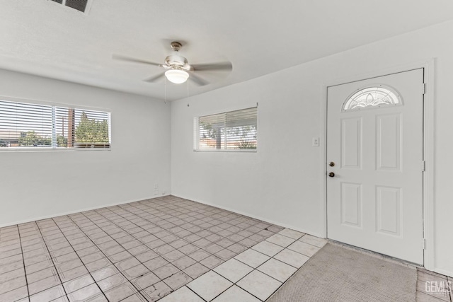 foyer entrance with ceiling fan and light tile patterned flooring