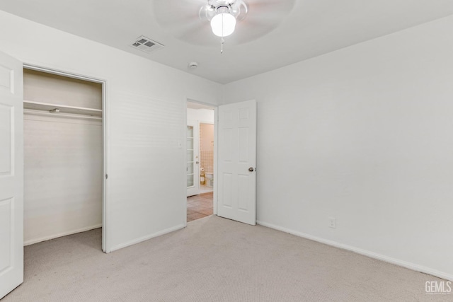 unfurnished bedroom featuring a closet, ceiling fan, and light colored carpet