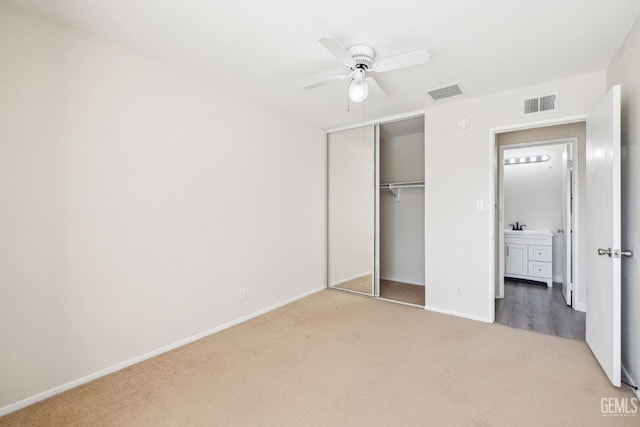 unfurnished bedroom featuring carpet flooring, ceiling fan, and a closet