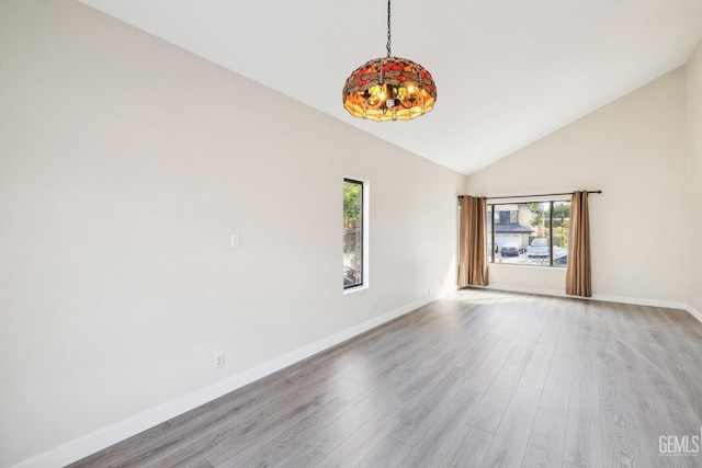 empty room with vaulted ceiling and light hardwood / wood-style flooring