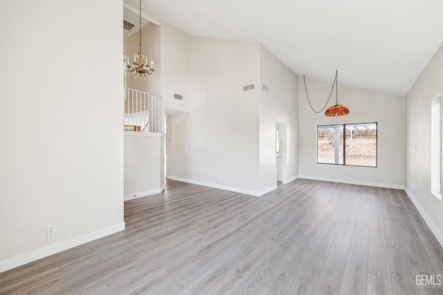 unfurnished living room with a chandelier, light hardwood / wood-style floors, and high vaulted ceiling