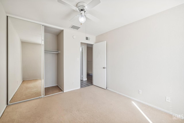 unfurnished bedroom featuring carpet flooring, a closet, and ceiling fan