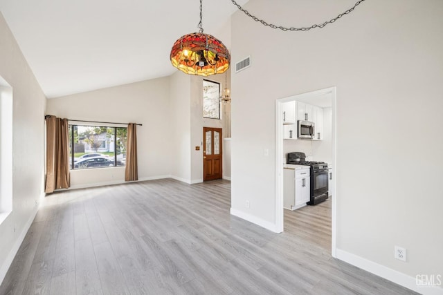 unfurnished living room with high vaulted ceiling and light hardwood / wood-style flooring