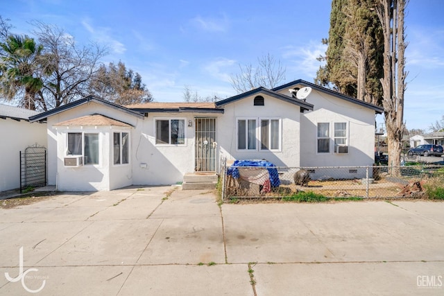 view of front of home with fence private yard, crawl space, cooling unit, and stucco siding