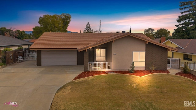 ranch-style home featuring a garage and a yard