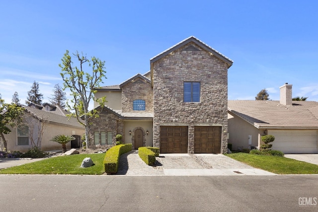 traditional home featuring stucco siding, decorative driveway, stone siding, and a garage
