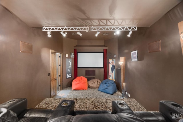 carpeted cinema room featuring track lighting