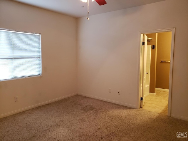 unfurnished room with ceiling fan and light colored carpet