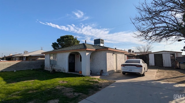 view of front of home featuring a storage shed and a front lawn