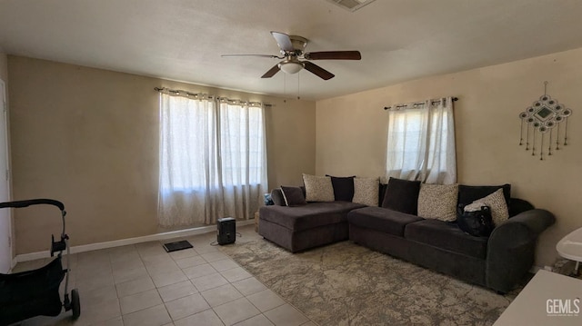 living room featuring ceiling fan, light tile patterned floors, and a wealth of natural light