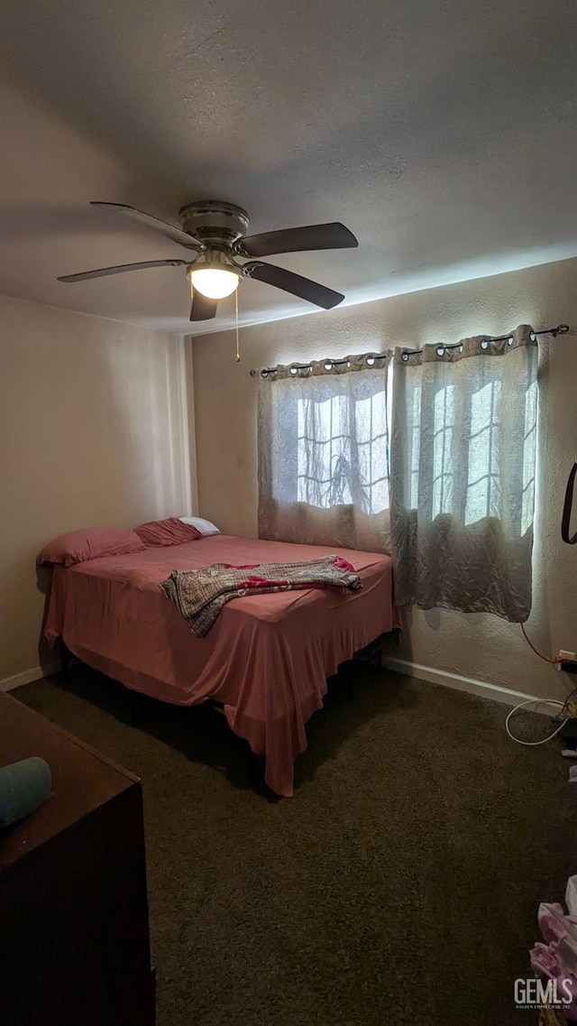 carpeted bedroom with ceiling fan and a textured ceiling