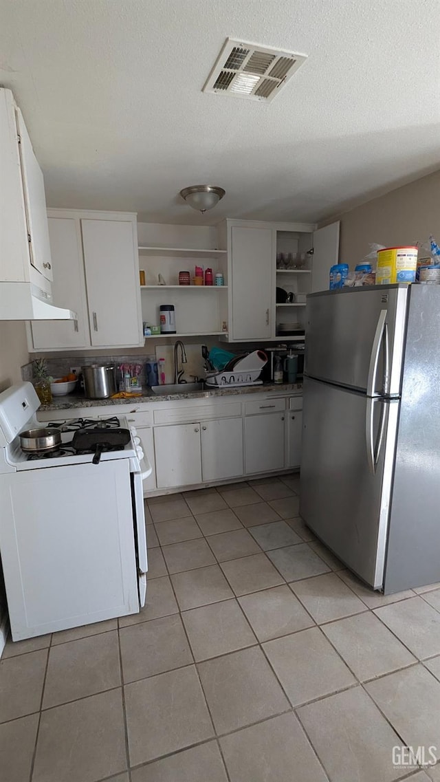 kitchen featuring sink, extractor fan, white cabinetry, stainless steel fridge, and white range with gas cooktop