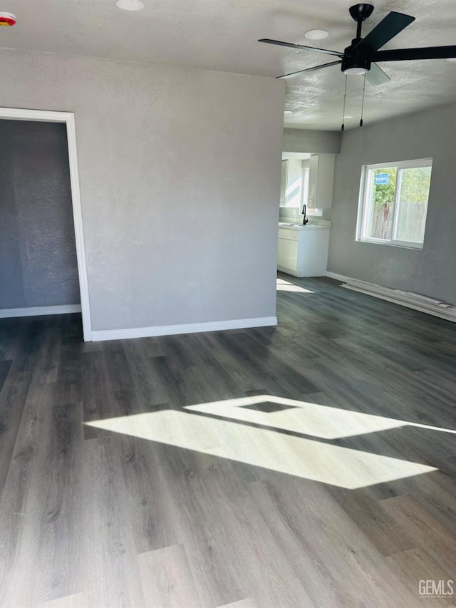 spare room featuring dark hardwood / wood-style flooring, ceiling fan, and sink