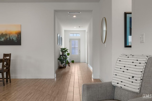 corridor with wood finished floors and baseboards