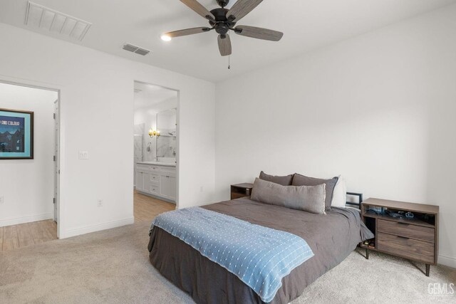 bedroom with carpet floors, baseboards, ensuite bathroom, and a ceiling fan