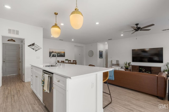 kitchen with a sink, open floor plan, white cabinets, recessed lighting, and a ceiling fan