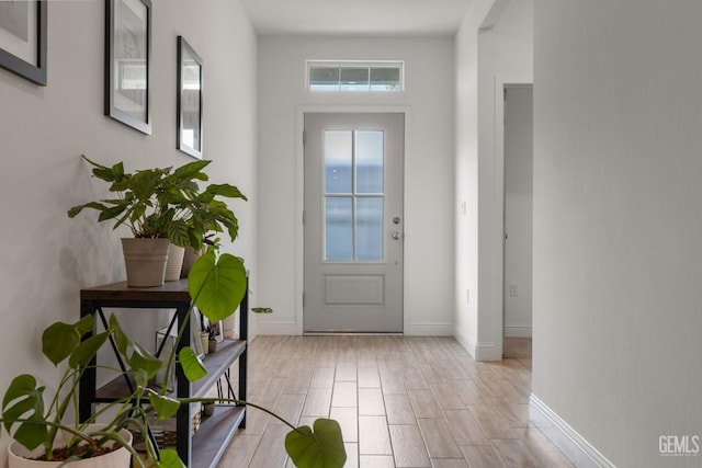 doorway with baseboards and light wood-style floors