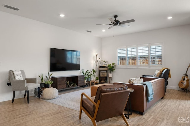 living room with light wood finished floors, a ceiling fan, recessed lighting, and baseboards