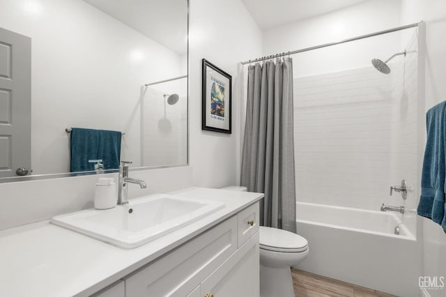 bathroom featuring wood finished floors, toilet, shower / bath combo with shower curtain, and vanity