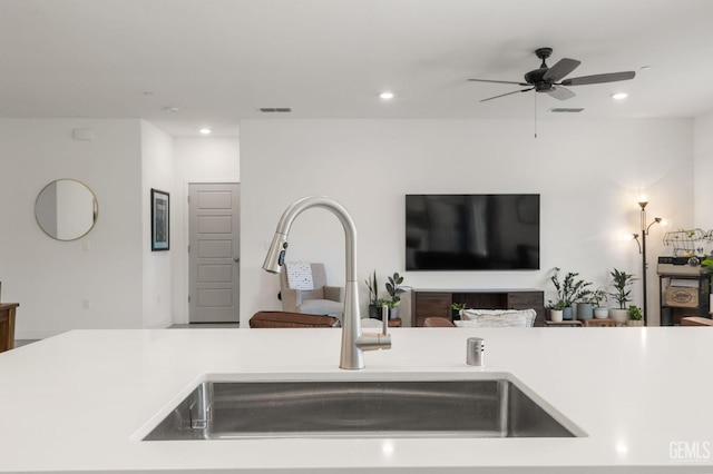kitchen featuring a sink, light countertops, recessed lighting, a ceiling fan, and open floor plan