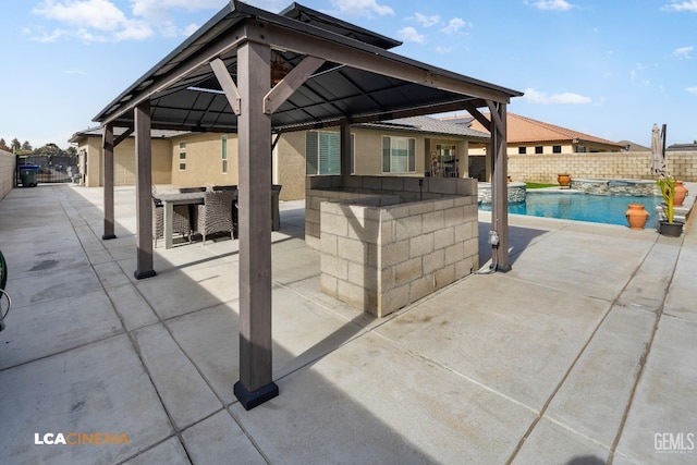 view of patio featuring a gazebo, a bar, and a fenced in pool