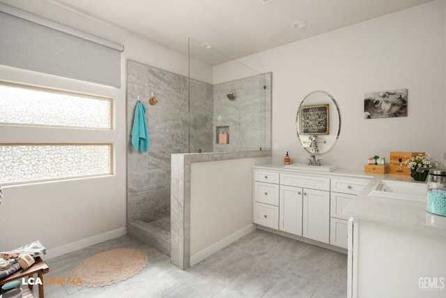 bathroom featuring a tile shower and vanity