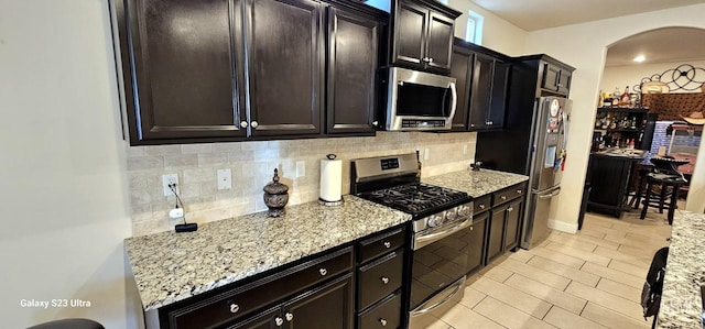 9211 Woodbrook Dr, Shafter, CA 93263 - kitchen with arched walkways, backsplash, and stainless steel appliances