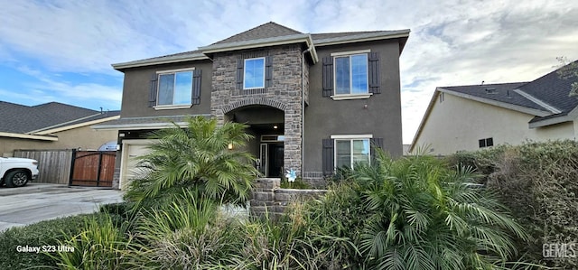 9211 Woodbrook Dr, Shafter, CA 93263 - view of front of property with stone siding, concrete driveway, stucco siding, and fence
