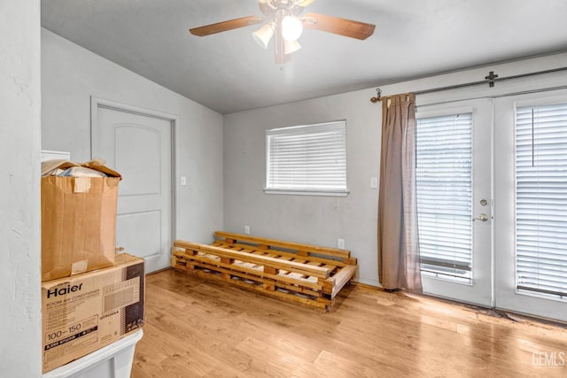 sitting room featuring vaulted ceiling, light wood-type flooring, a wealth of natural light, and ceiling fan