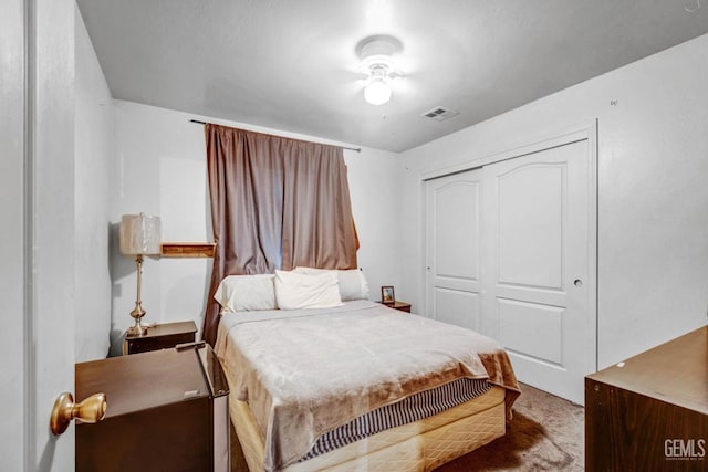 carpeted bedroom with visible vents and a closet